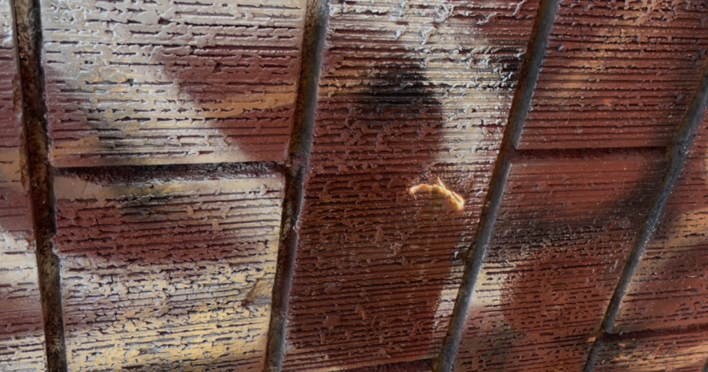 Laser removal of spray paint graffiti from a textured brick wall, partially restored to its original color, Los Angeles, CA